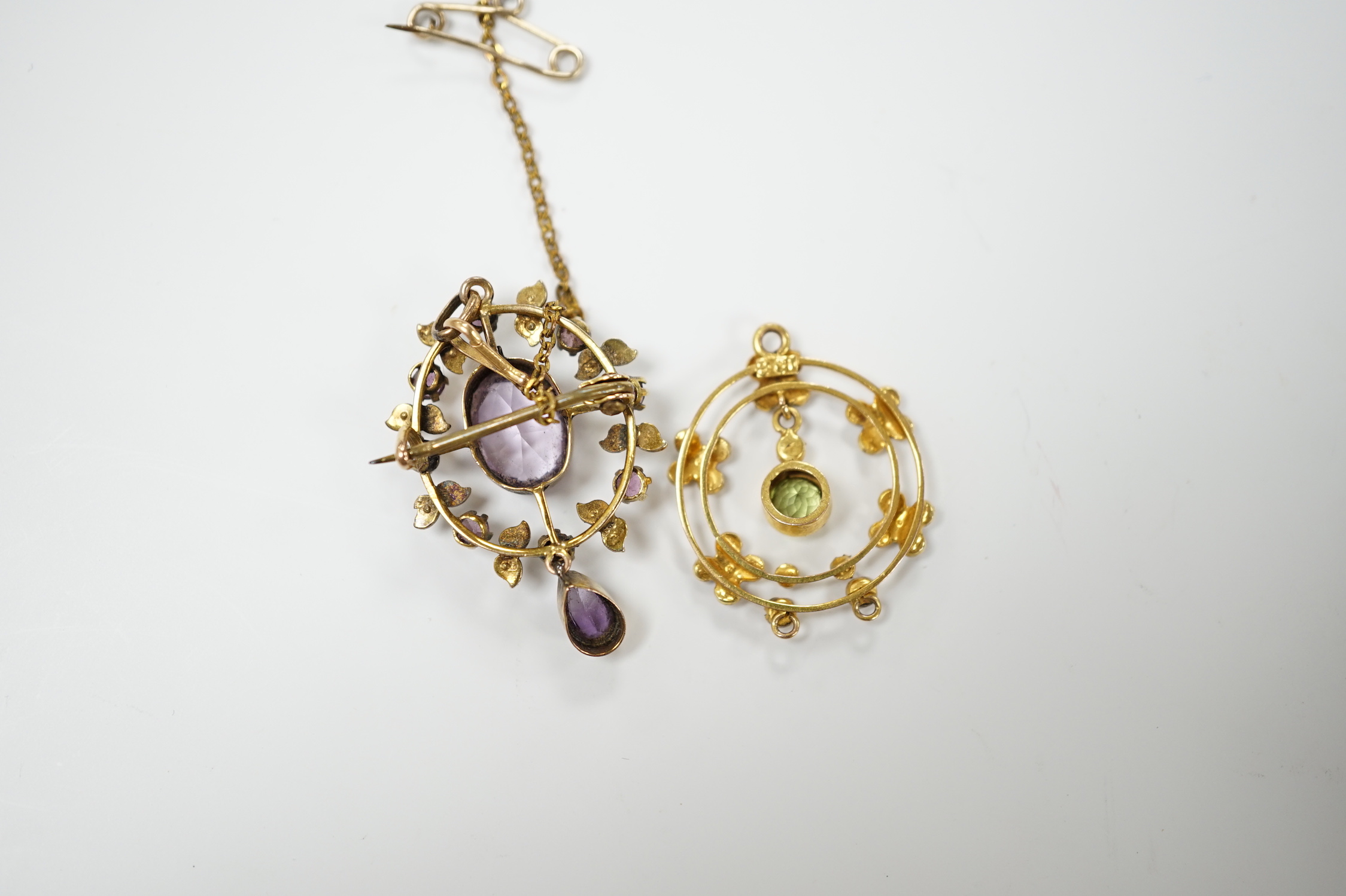 An early 20th century 9ct, peridot and seed pearl set drop pendant, 25mm and one other yellow metal and gem set pendant.